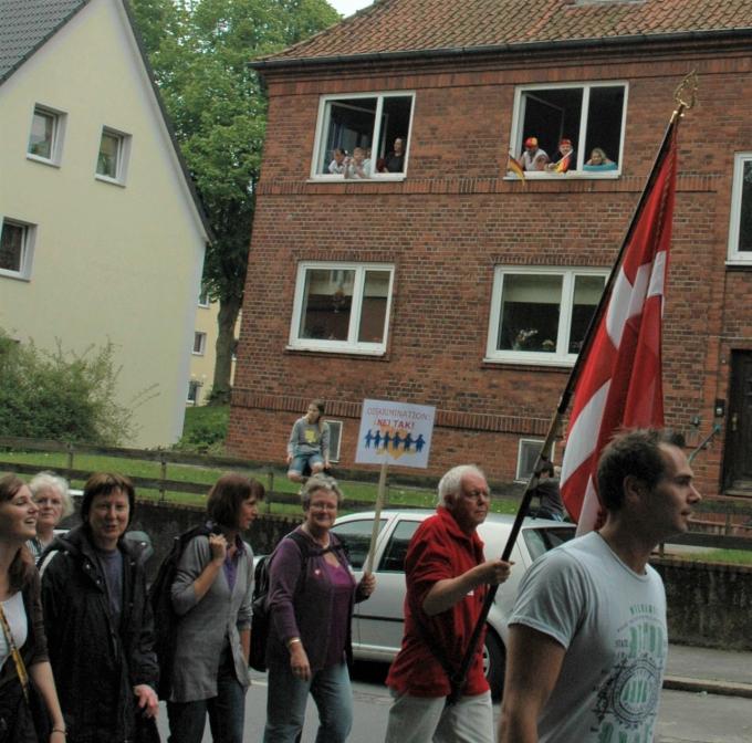 Indbyggere i Flensborg ser til fra vinduerne med tyske flag under årsmødeoptog. Indbyggere i Flensborg ser til fra vinduerne med tyske flag under årsmødeoptog.