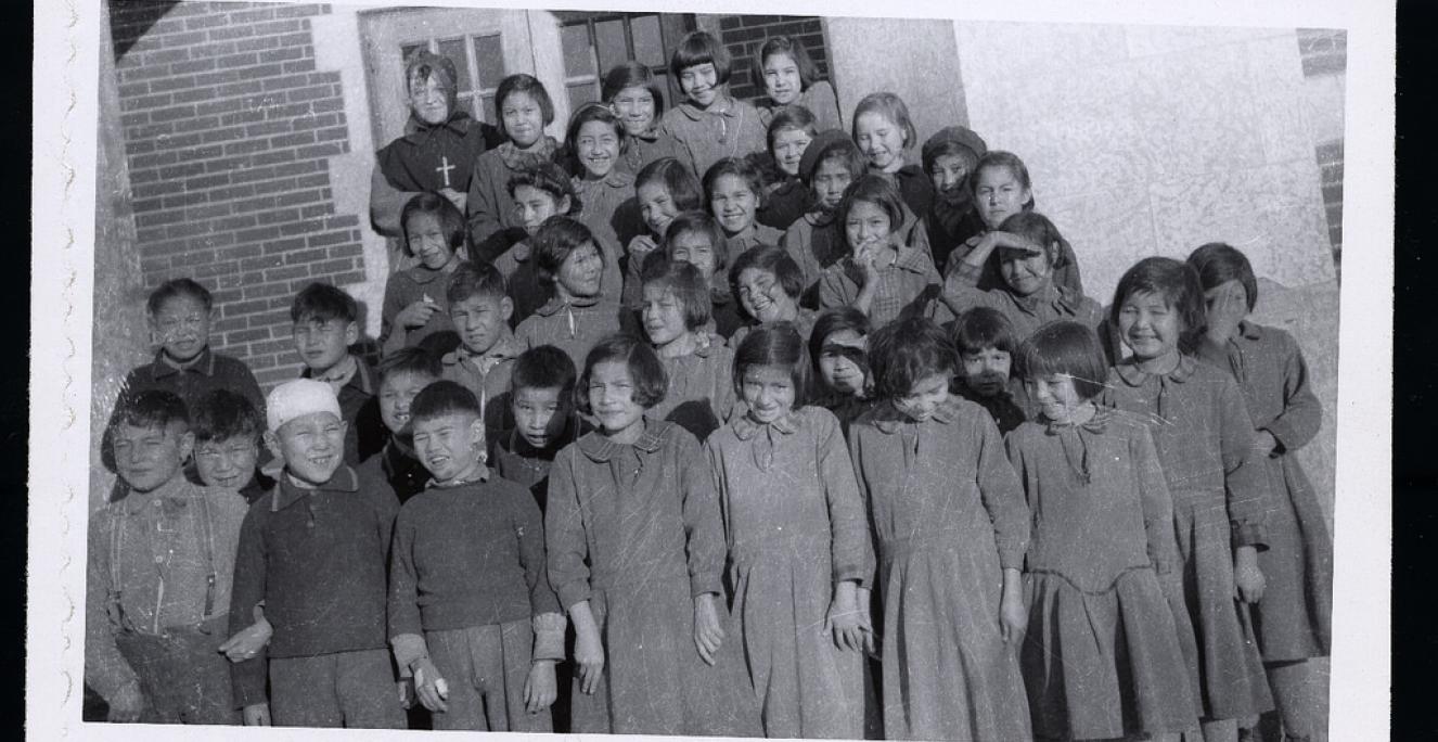 Elever på Blue Quills Residential School i Alberta, Canada. Systemet af såkaldte residential schools i Canada eksisterede fra 1880'erne til slutningen af 1900-tallet og havde til formål at assimilere indfødte børn ved at fjerne dem fra deres familier og fratage dem deres kulturelle og sproglige særtræk. Elever på Blue Quills Residential School i Alberta, Canada. Systemet af såkaldte residential schools i Canada eksisterede fra 1880'erne til slutningen af 1900-tallet og havde til formål at assimilere indfødte børn ved at fjerne dem fra deres familier og fratage dem deres kulturelle og sproglige særtræk.